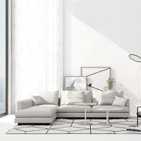 Modern living room with a white sectional sofa, abstract art, and a geometric rug.
