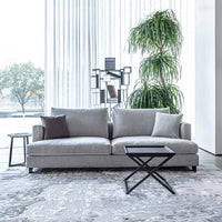 Gray sofa in a modern living room with a plant and side table.