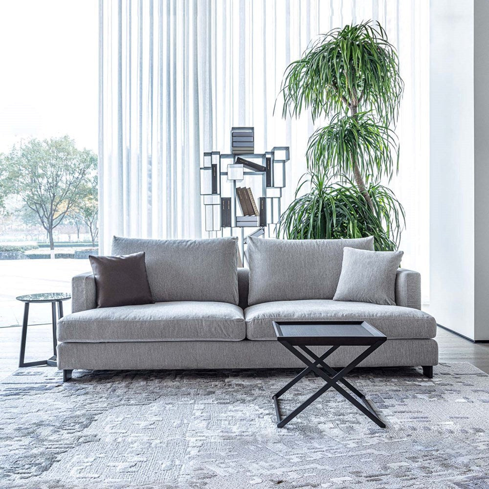 Gray sofa in a modern living room with a plant and side table.