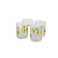 Set of four clear glass tumblers with a yellow pineapple print, on white