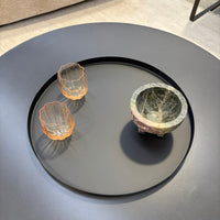 Roxy tray in black on a table holding orange glass bowls and a marble bowl