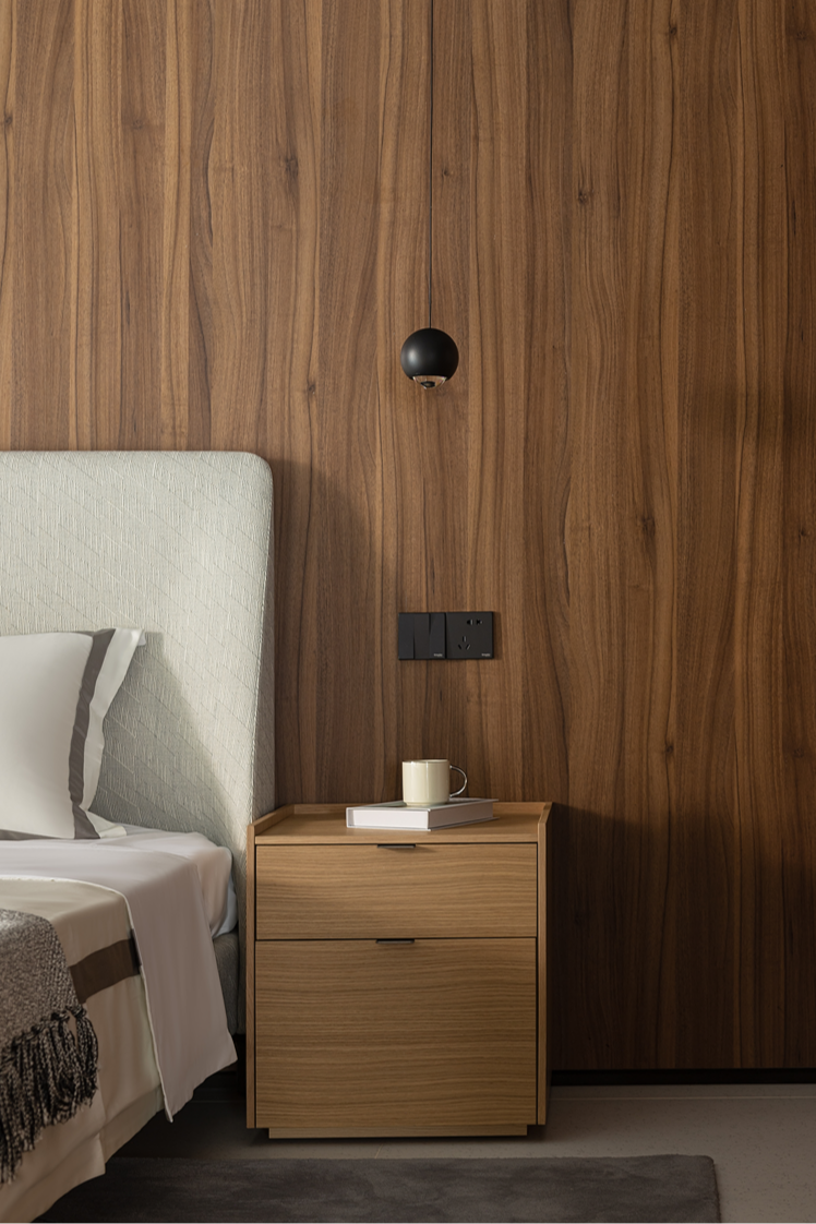 Matrix narrow 2-drawer bedside in light oak beside a bed with a timber-panelled wall