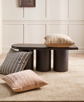 Corbett floor rug in a living room with dark round timber coffee tables and a cushion
