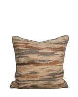 Nerida cushion in a woven brushstroke pattern of rust, grey and cream, angled view