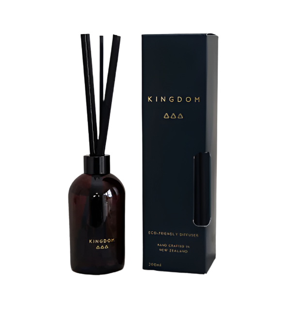 Kingdom silk fibre diffuser in a dark amber glass bottle with black reeds beside its navy box