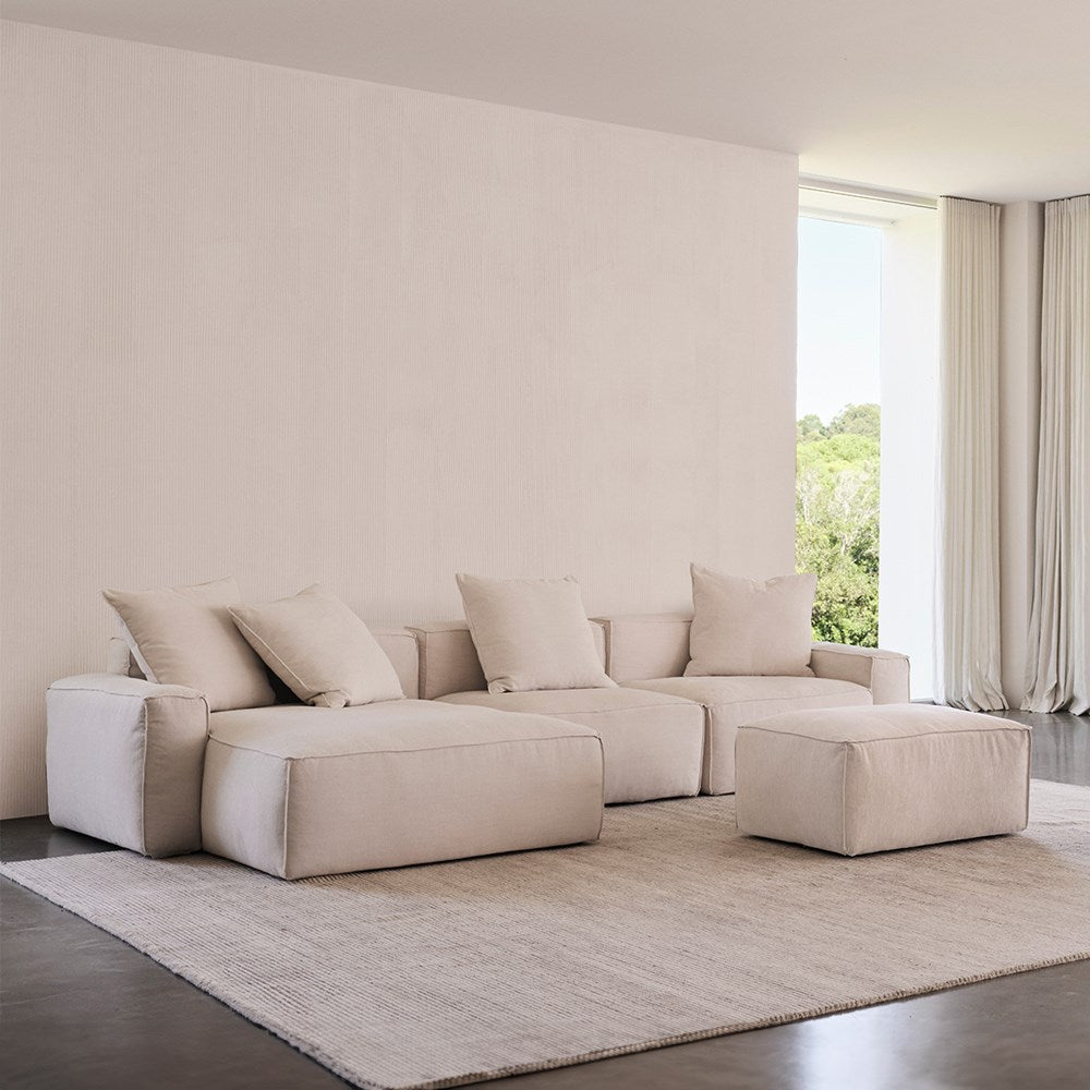 Elio Junior 5-piece corner sofa and ottoman in cream fabric in a living room with a sheer window