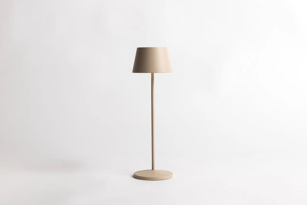 Serene cordless table lamp in sand with a slim stem and round base, on a white background