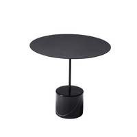 Calibre low side table with a round black top on a slim stem and a black marble base